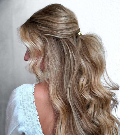 KELA Ponytail Halo Hair Clip Ponytail Holder in gold securing a wavy blonde half-up ponytail with loose curls
