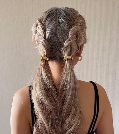 KELA Ponytail Halo Hair Clip Ponytail Holder in gold finish securing two blonde braided ponytails with a polished, tension-free hold